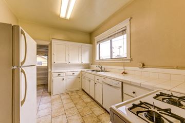 Denver apartment for rent - A kitchen with a refrigerator, stove, and cabinets.