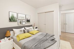 Denver apartment for rent - A bedroom with a bed, a nightstand, and a lamp.