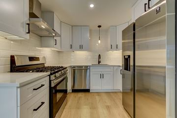 Boulder townhouse for rent - a kitchen with white cabinets and stainless steel appliances
