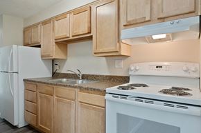Westminster apartment for rent - A kitchen with a white stove and wooden cabinets.