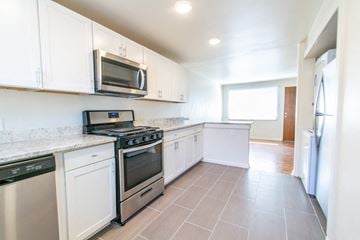 Wheat Ridge apartment for rent - A kitchen with white cabinets and appliances.