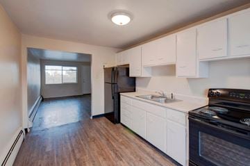 Denver apartment for rent - A kitchen with white cabinets and a black stove top oven.