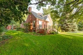 Boulder triplex for rent - a small brick house with a porch and a grass yard