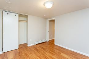 Boulder triplex for rent - a bedroom with white walls and wood flooring and a closet