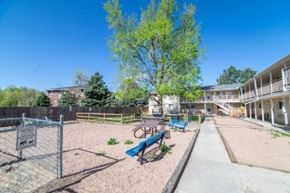 Arvada apartment for rent - A playground with a blue swing set and a fence.
