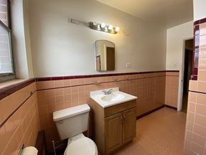 Denver apartment for rent - A bathroom with a toilet, sink, and mirror.