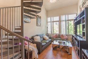 Boulder apartment for rent - A living room with a couch, a coffee table, and a staircase.