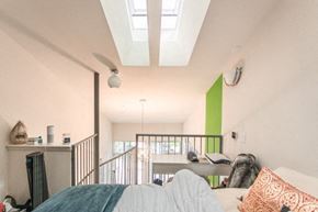 Boulder apartment for rent - A bedroom with a bed, a couch, and a green accent wall.