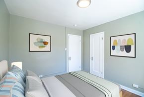 Wheat Ridge apartment for rent - A bedroom with a bed and two framed pictures on the wall.