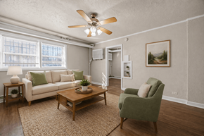 Denver apartment for rent - A living room with a white couch, green armchair, and a coffee table.