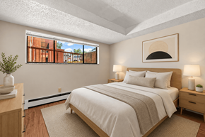 Boulder apartment for rent - A bedroom with a large bed and a window overlooking a brick building.
