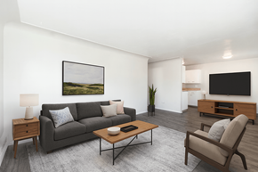 Aurora apartment for rent - A living room with a grey couch, a wooden coffee table, a lamp, a painting, a television, and a plant.
