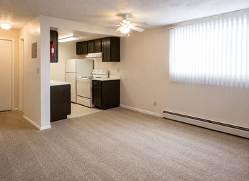 Greeley apartment for rent - A kitchen area with a white stove and black cabinets.