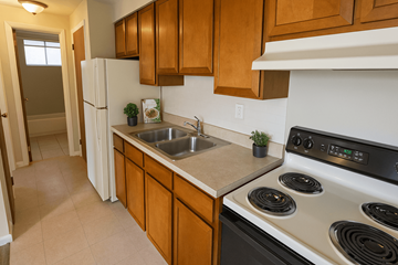 Denver apartment for rent - A kitchen with a white stove top oven and a white refrigerator.