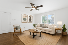 Denver apartment for rent - A living room with a white couch, a chair, a coffee table, and a ceiling fan.