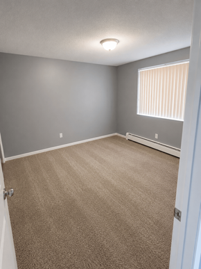Englewood apartment for rent - A room with a carpeted floor and a window with blinds.