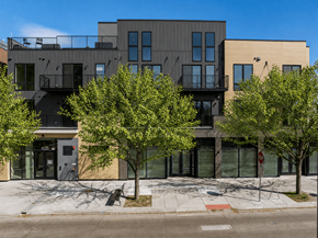 Denver apartment for rent - A modern building with a balcony and a tree in front of it.