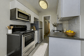 Lakewood apartment for rent - A modern kitchen with a black stove top oven and a silver microwave above it.