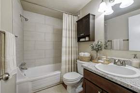 Lakewood apartment for rent - A white bathroom with a toilet, sink, and bathtub.