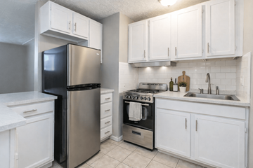 Englewood apartment for rent - A kitchen with white cabinets and a stainless steel refrigerator.