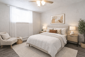 Englewood apartment for rent - A bedroom with a large bed, a chair, and a ceiling fan.