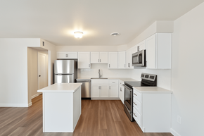 Boulder triplex for rent - A white kitchen with wood floors and stainless steel appliances.