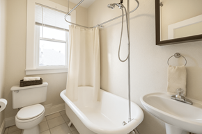 Denver apartment for rent - A white bathroom with a toilet, sink, and bathtub.