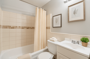 Aurora apartment for rent - A bathroom with a white tub, toilet, and sink.