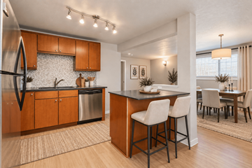 Denver apartment for rent - A modern kitchen with wooden cabinets and a bar area.
