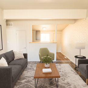 Denver apartment for rent - A living room with a grey couch, a green chair, a wooden coffee table, and a lamp.