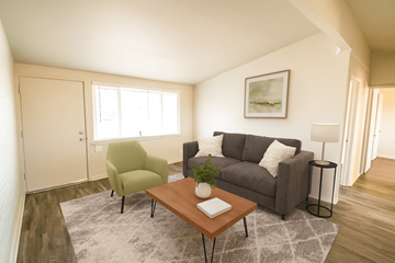 Denver apartment for rent - A living room with a green chair and a grey couch.