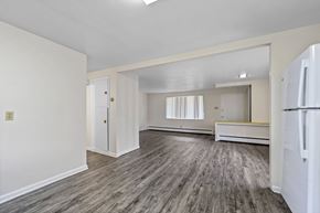 Lakewood apartment for rent - A spacious room with a white refrigerator on the right side.