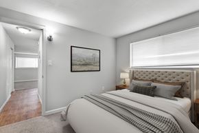 Denver apartment for rent - A bedroom with a large bed and a painting on the wall.