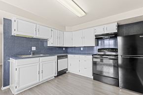 Lakewood apartment for rent - A kitchen with white cabinets and a black refrigerator.