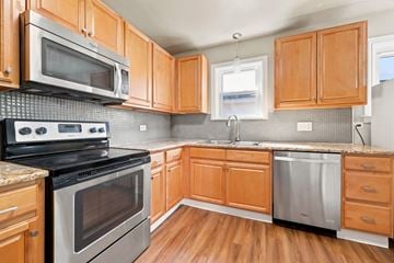 Denver apartment for rent - A kitchen with wooden cabinets and stainless steel appliances.