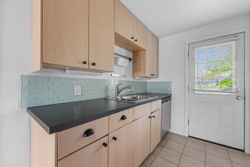 Denver apartment for rent - A kitchen with wooden cabinets and a black countertop.