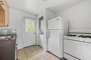 Denver apartment for rent - A kitchen with white appliances and a window.