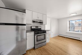 Denver apartment for rent - A kitchen with white appliances and wooden floors.