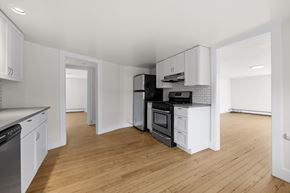 Denver apartment for rent - A kitchen with white cabinets and a wooden floor.