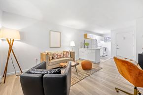 Englewood apartment for rent - A living room with a black leather sofa and a wooden floor.