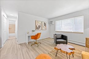 Englewood apartment for rent - A living room with a white desk, a black chair, and a wooden coffee table.