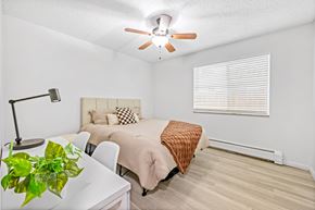 Englewood apartment for rent - A bedroom with a bed, a ceiling fan, and a window with blinds.