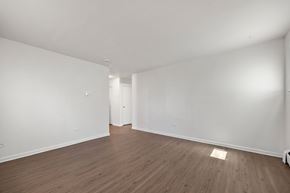 Commerce City apartment for rent - Empty room with wooden floor and white walls.