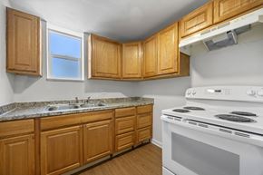 Commerce City apartment for rent - A kitchen with wooden cabinets and a white stove.