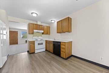 Lakewood apartment for rent - A kitchen with wooden cabinets and white appliances.