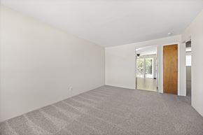 Lakewood apartment for rent - A room with a carpeted floor and a door leading to a balcony.