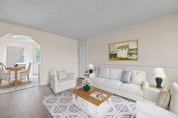 Denver apartment for rent - A living room with a white couch, a coffee table, and a painting on the wall.
