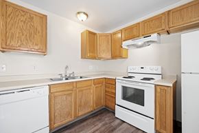 Denver apartment for rent - A kitchen with wooden cabinets and white appliances.