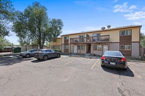 Denver apartment for rent - A parking lot with a building and cars.