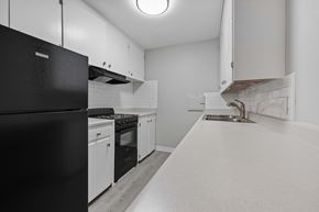 Lakewood apartment for rent - A black refrigerator is on the left in a white kitchen.